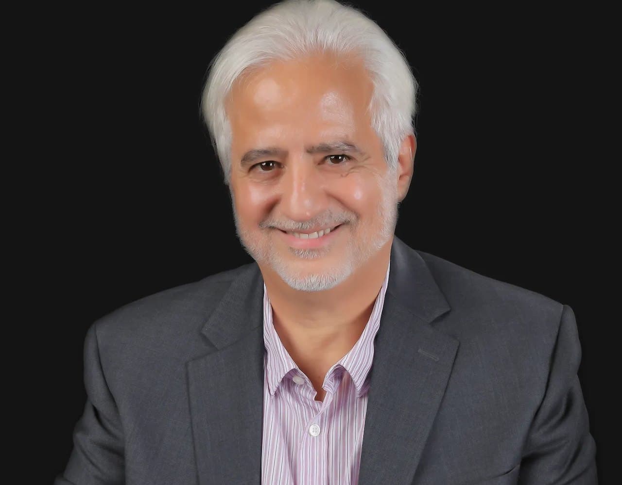 AJ Rassamni, founder of Success From Within, smiling in a studio portrait